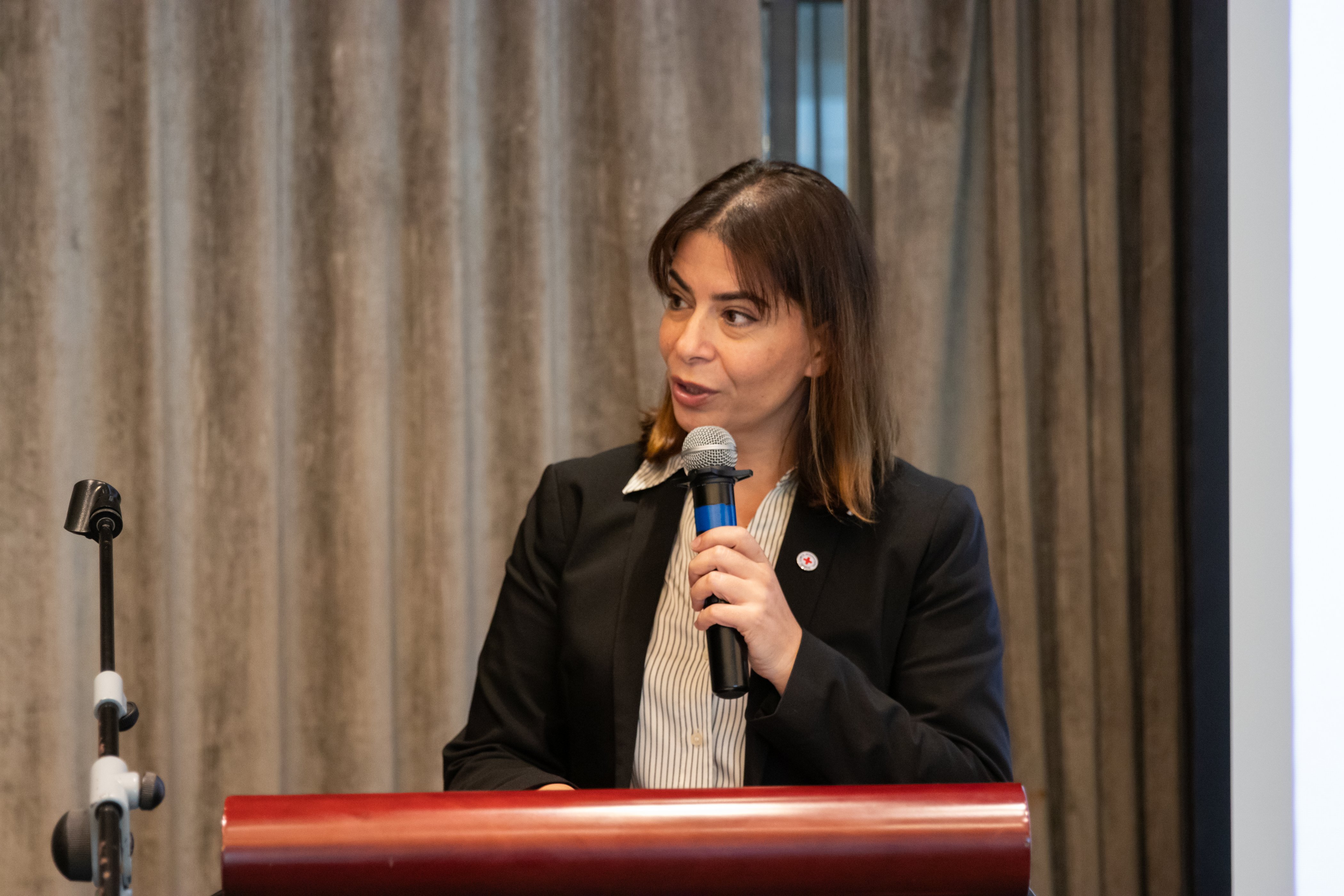 Layal Neaimeh, ICRC Coordinator for Humanitarian Affairs, speaking on a podium