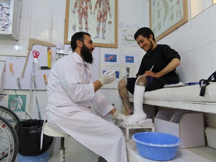 A doctor treats a boy with a physical disability in Afghanistan.