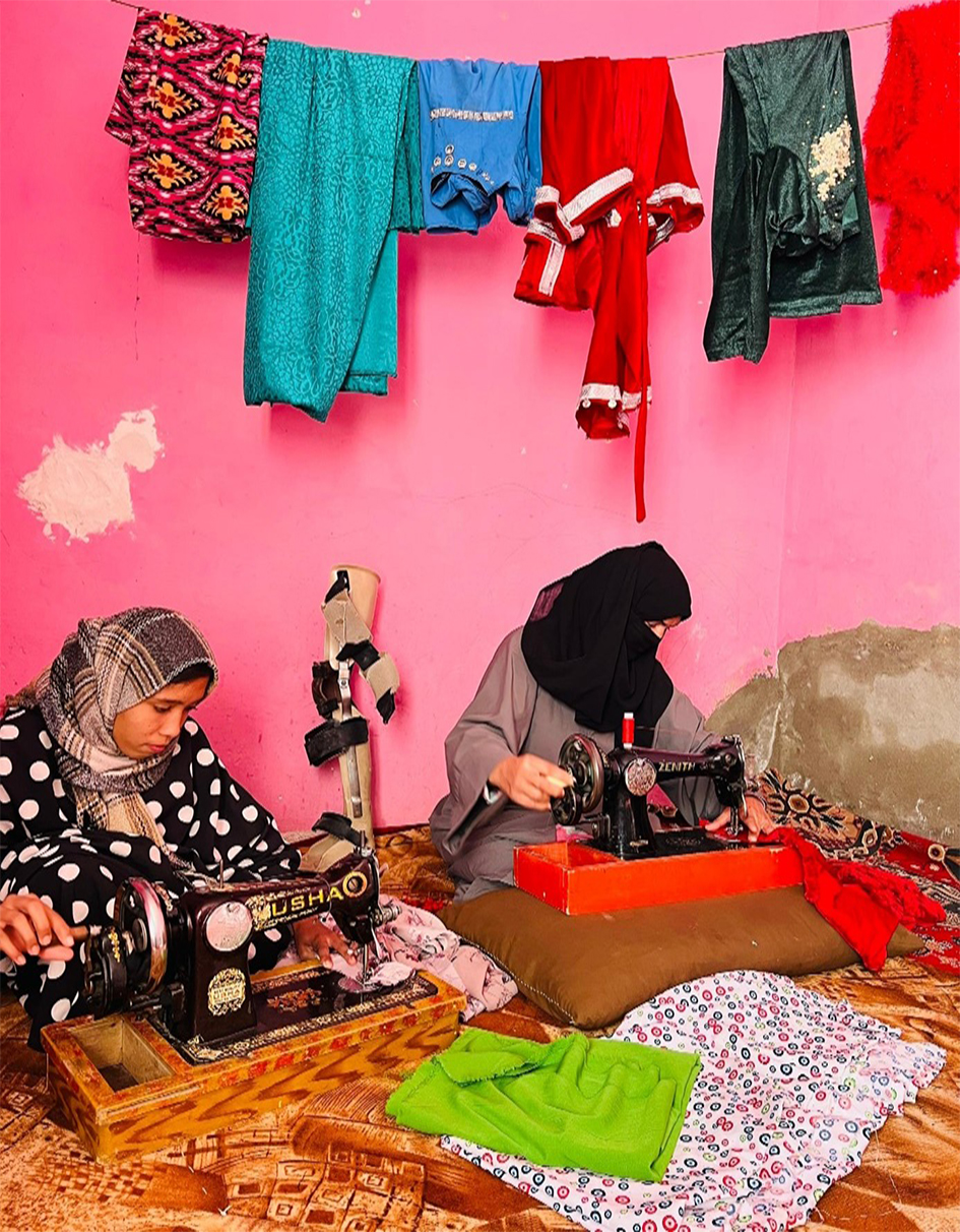 Two women work with sewing machines.