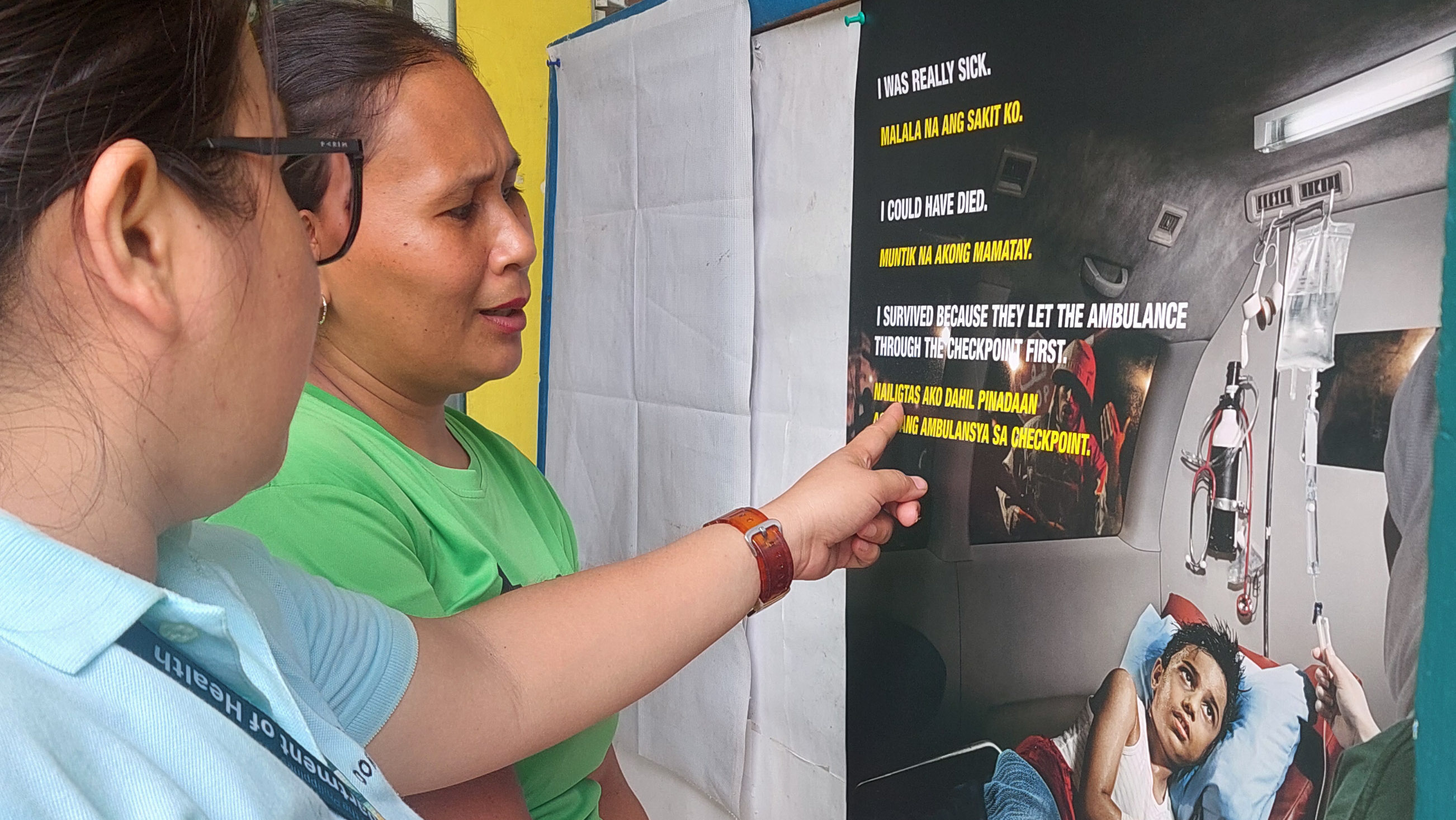 Health workers from the Barangay Bangonay health station in Jabonga, Agusan del Norte install a poster promoting safe access for ambulances during emergencies. Photo: R. Esguerra / ICRC.