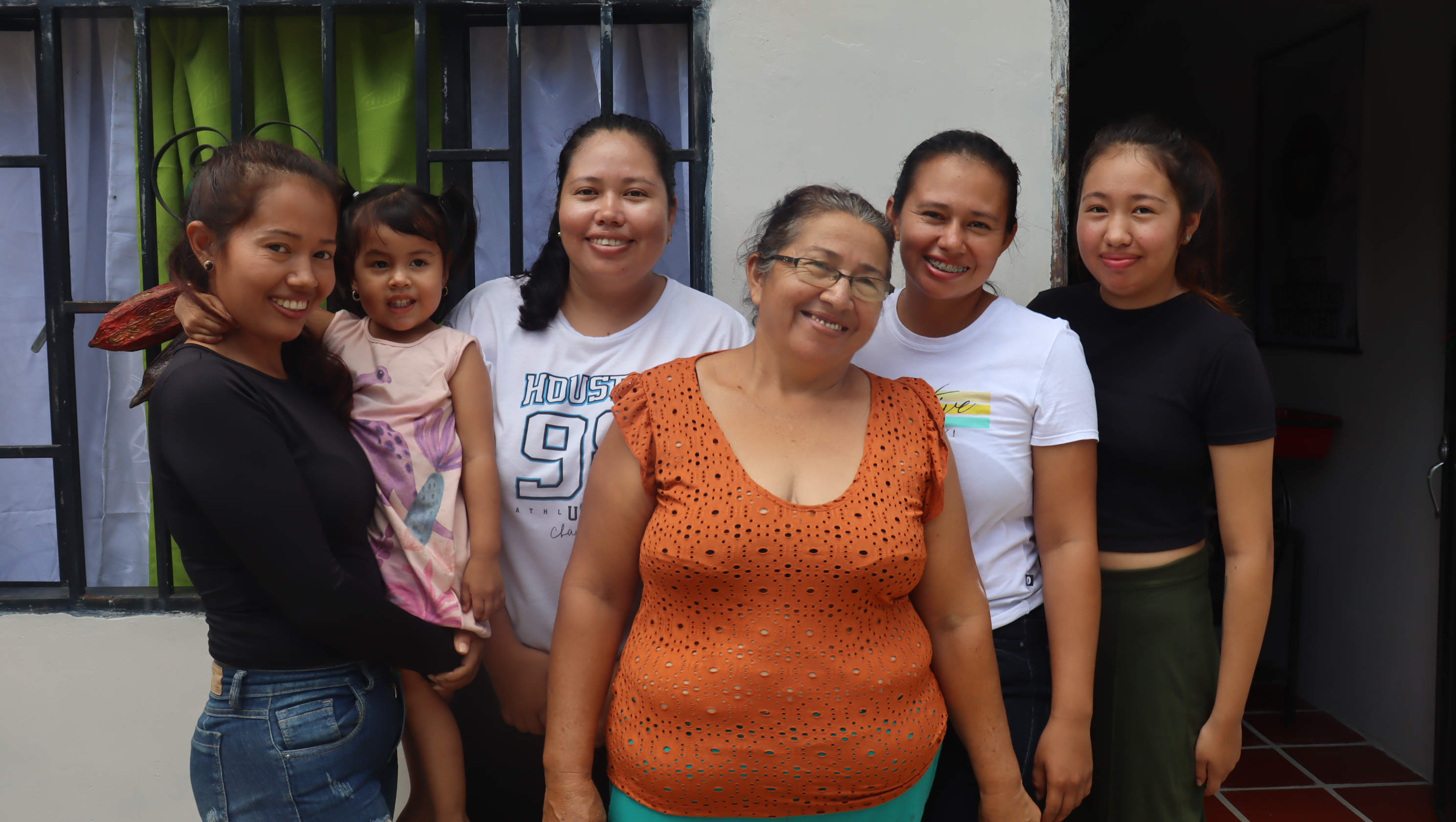 Mujeres de varias generaciones sonríen para la cámara.