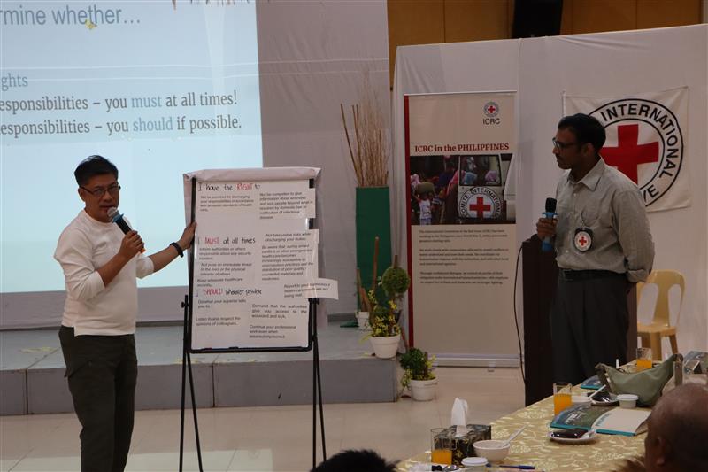 Napoleon Ashley Lopez (left), administrative officer of Agusan del Norte Provincial Health Office, shares their insights on the rights and responsibilities of health care workers especially during armed conflict and other situations of violence. The session was facilitated by Dr. Srinivasa Ghattamaneni, ICRC Health Delegate (right). Photo: M. Lucero/ICRC.