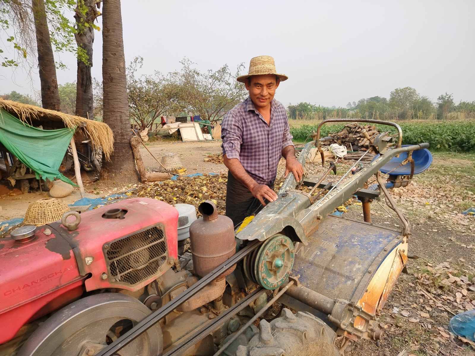 A farmer operates machinery in a field in Myanmar.