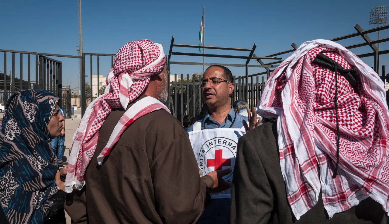 In eastern Jordan, Mafraq, an ICRC employee tells Syrian refugees about the services available to re-establish contact with relatives.