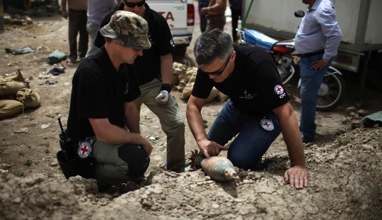 ICRC explosive ordnance disposal staff inspect an unexploded ordnance near a military checkpoint in Amara, Libya.