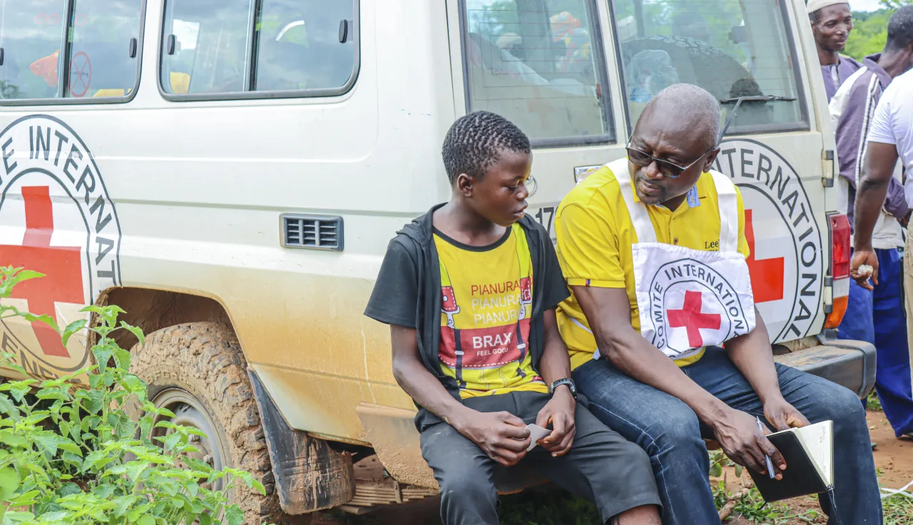An ICRC employee talks to a child during a distribution of essential household items.