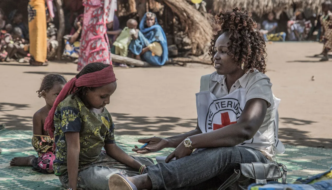 An ICRC worker talks to a young girl at Kaga-Bandoro, Mbella, Central African Republic, in a camp for displaced people.