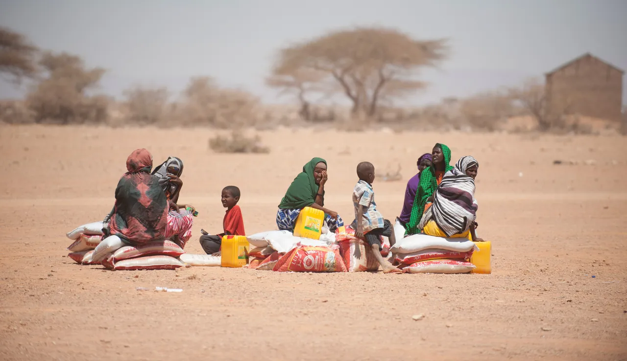  People sitting under the harsh sunlight after a food distribution organized by the ICRC. 