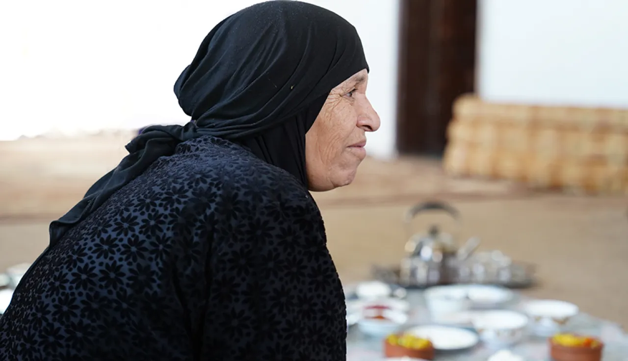 Anoud Jordan IDOD Anoud looking away from the camera with food she has prepared in the background