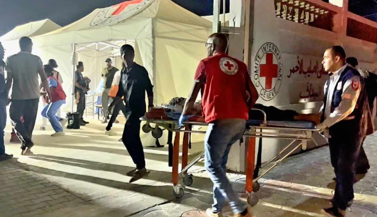 ICRC staff with a patient being transferred to the field hospital