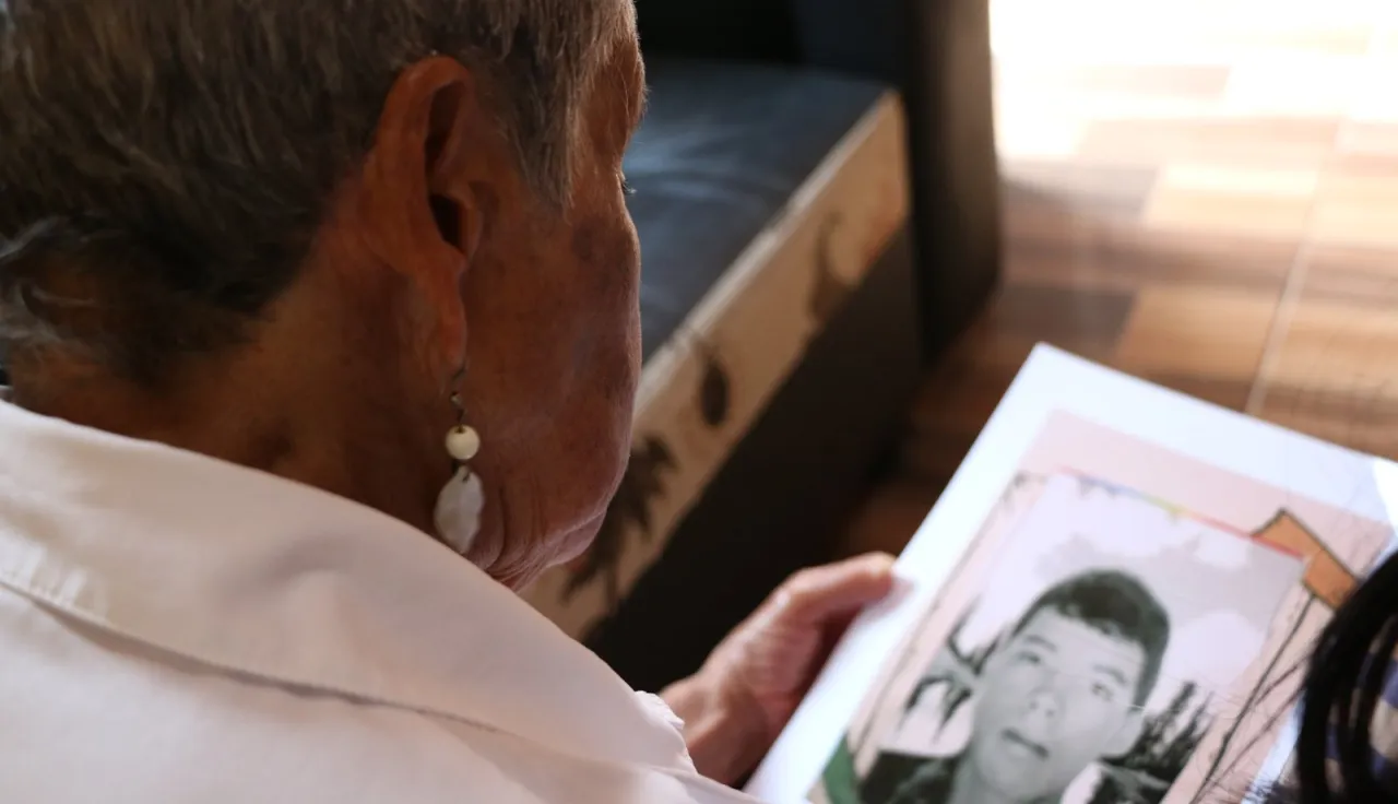 Un hombre mira una foto de su hijo desaparecido.