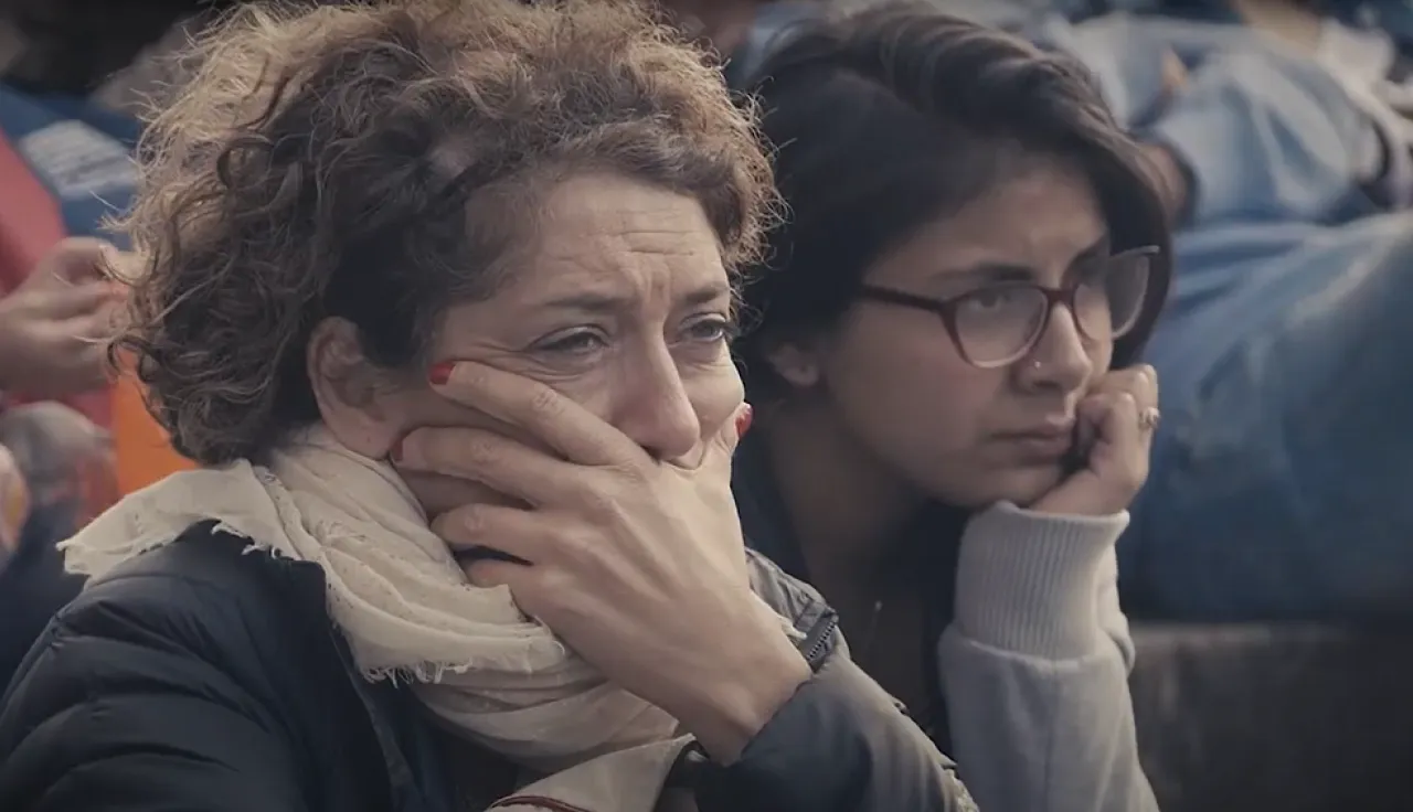 Dos mujeres observan consternadas algo que les cause evidente conmoción.