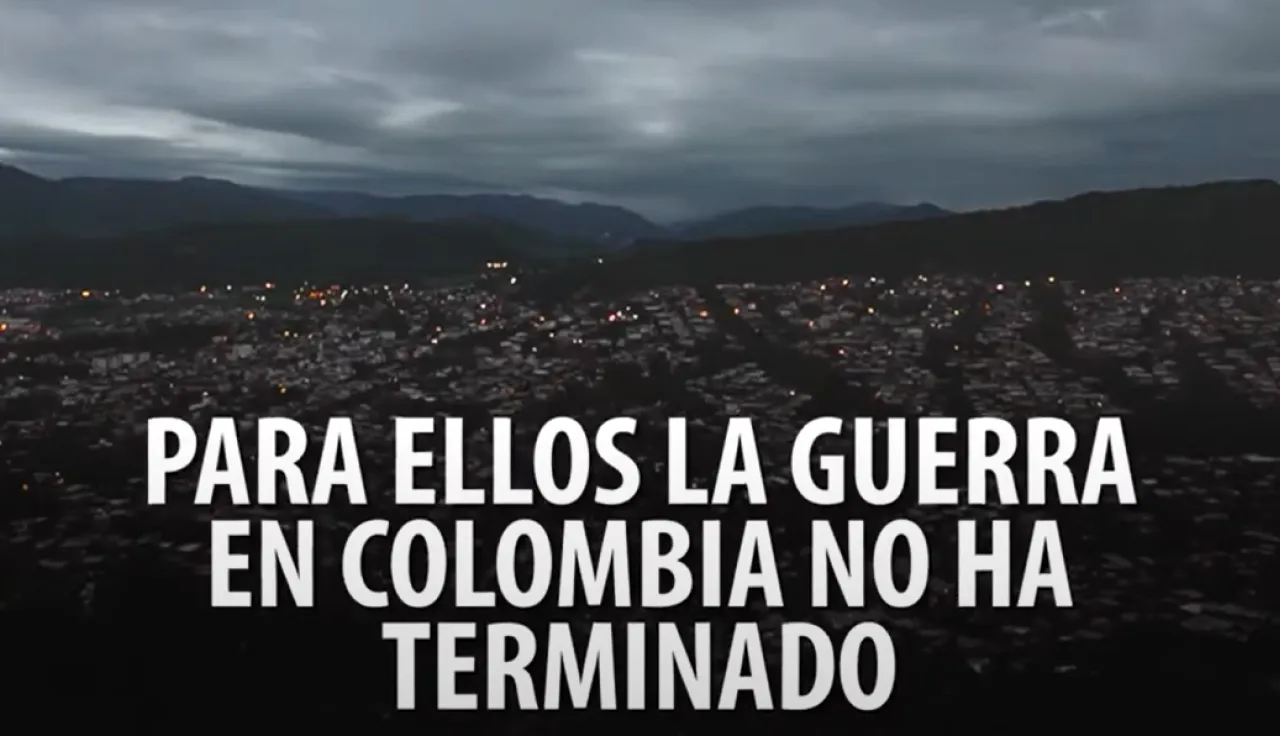 Vista panorámica de una ciudad detrás de una leyenda que dice: Para ellos la guerra en Colombia no ha terminado.