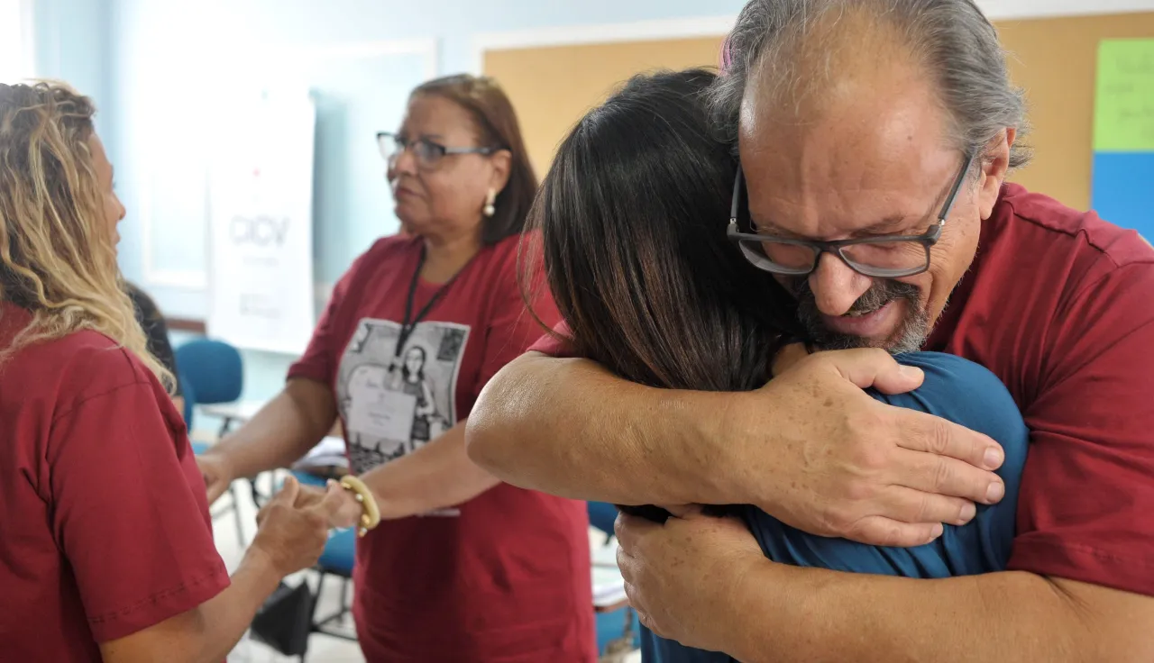 Pessoas se abraçam com emoção.