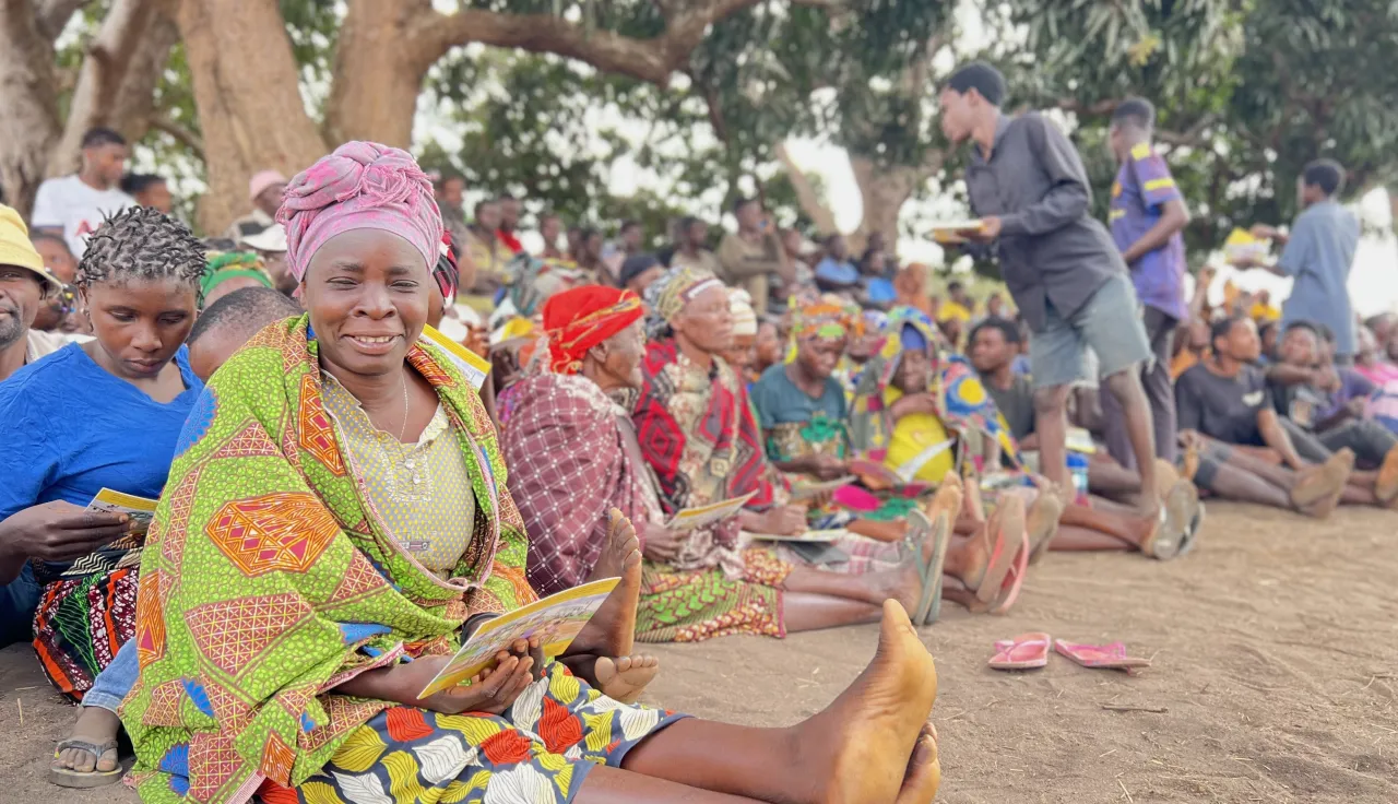 Mulheres de uma comunidade estão sentadas durante distribuição de ajuda.