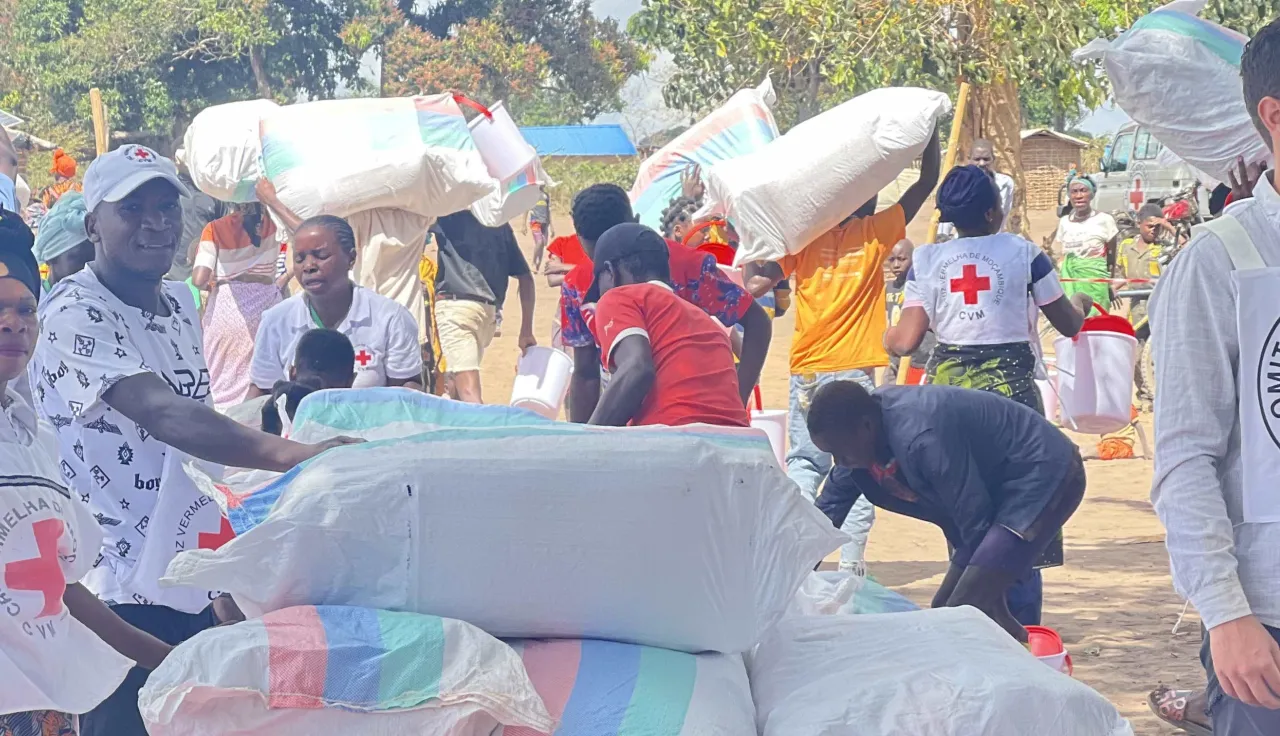 Equipes do CICV e da Cruz Vermelha de Moçambique distribuyen ayuda en una comunidad.