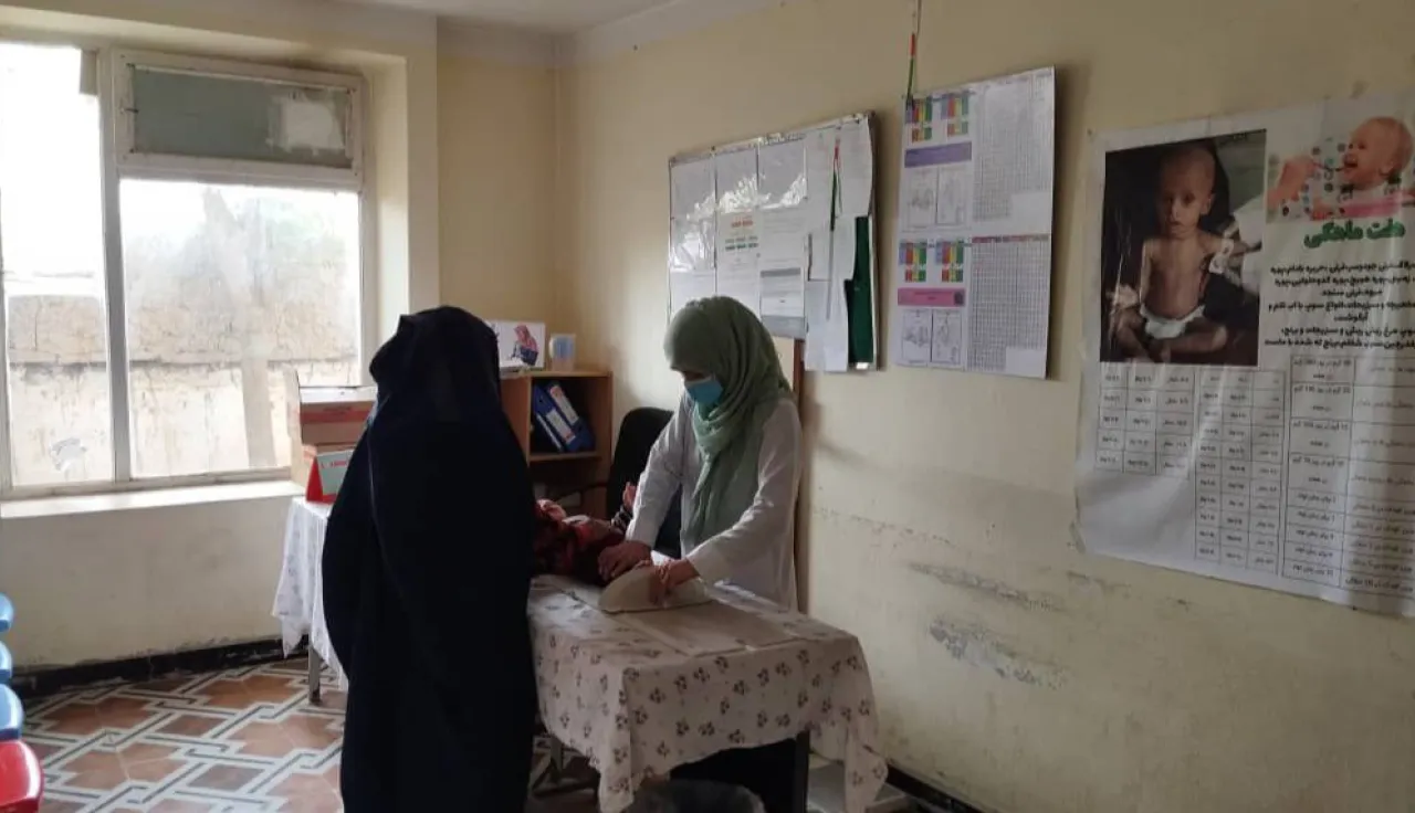 An Afghan Red Crescent Soceity healthcare worker providing assistance to a patient