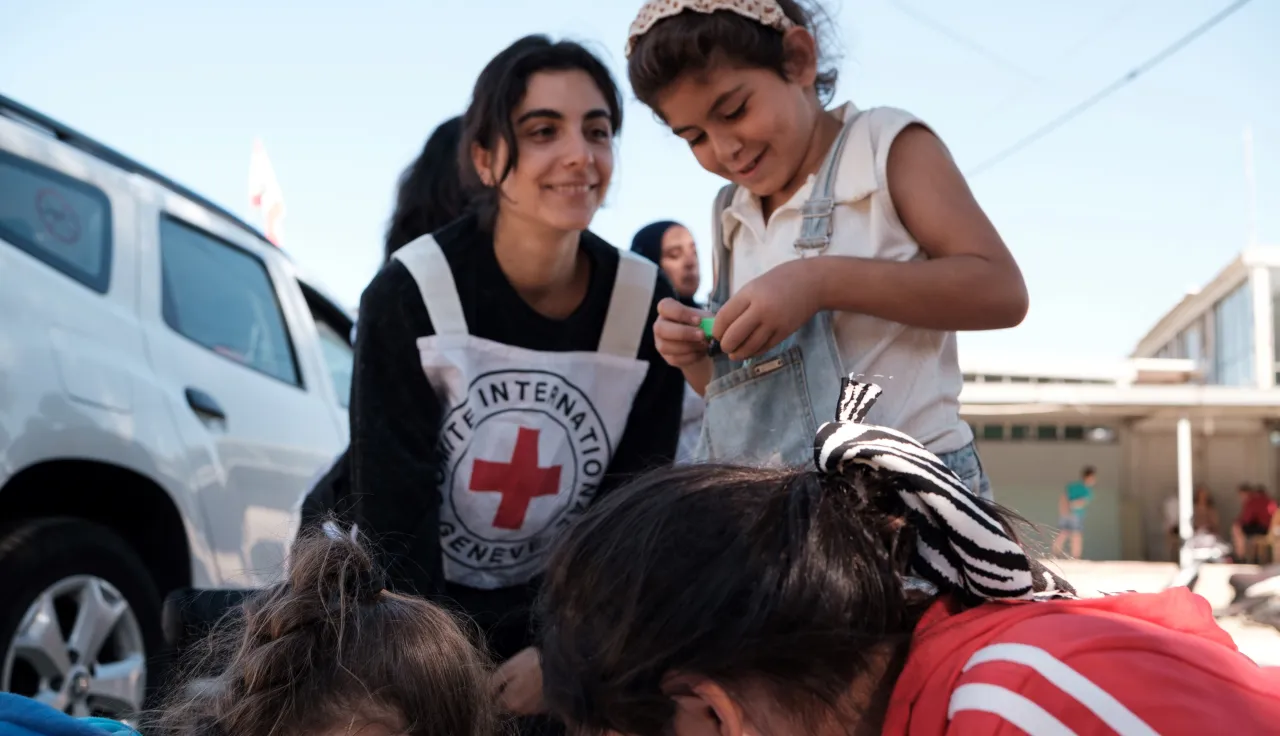 Kids at the shelter playing with an ICRC worker