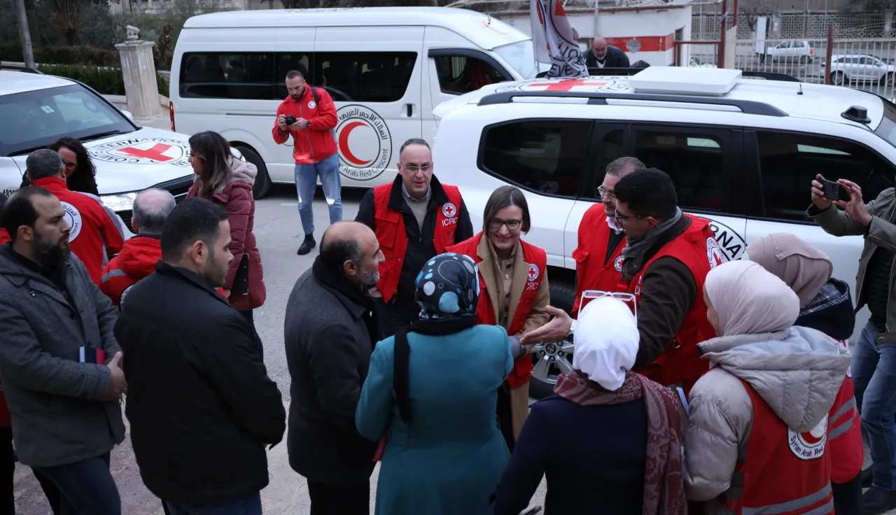 President Mirjana Spoljaric in a group with Red Crescent van in the background