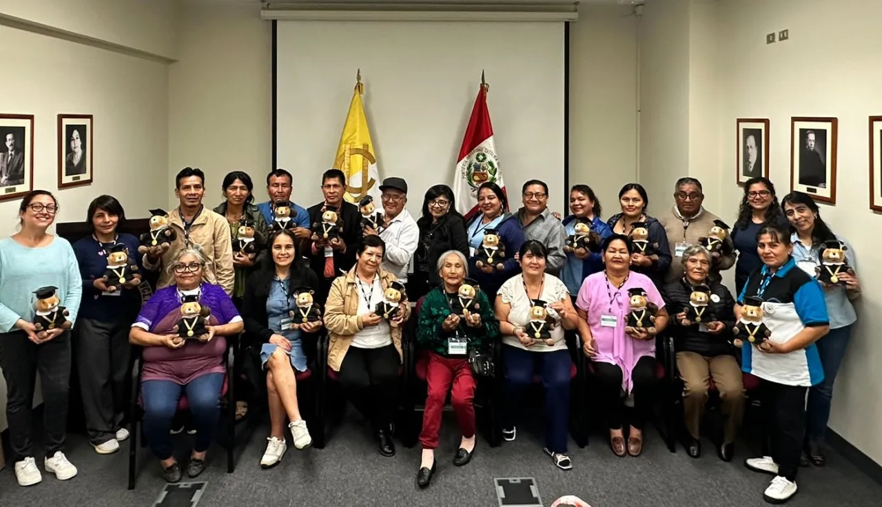 Familiares de personas desaparecidas posan en una foto grupal con reconocimientos por su formación.