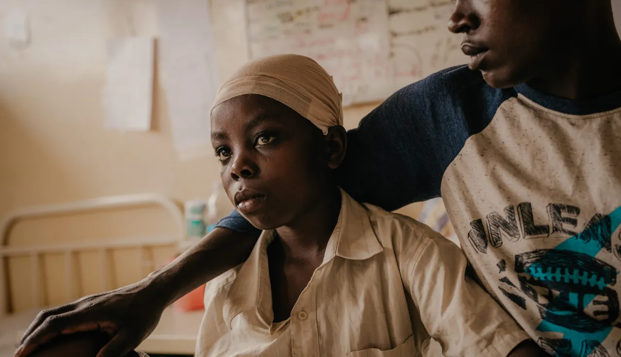 Grace, un niño de 10 años que recibió un disparo en la cabeza (de manos del grupo de rebeldes M23), está al cuidado de su hermano James después de su cirugía. Desde que resultó herido, Grace no ha vuelto a hablar. 
