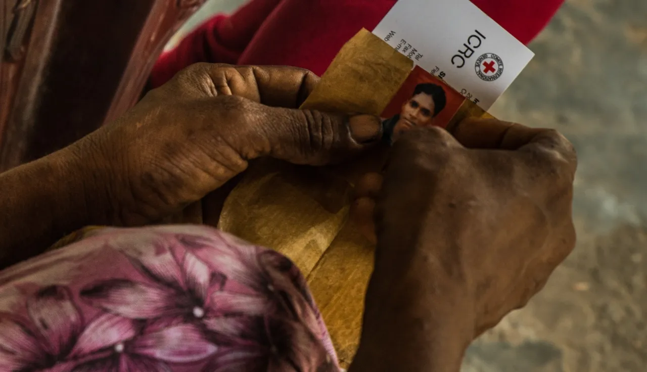 A woman's hands holding a picture of a missing loved one. ICRC