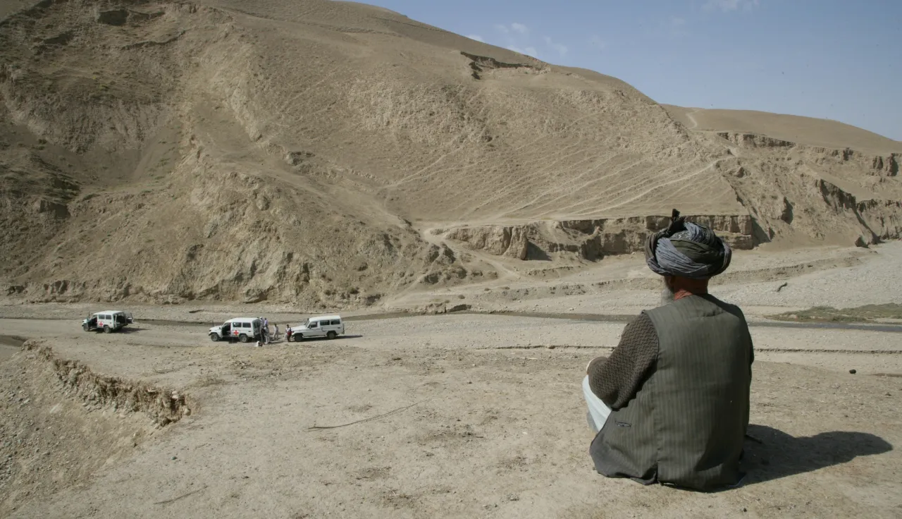 A man overlooks ICRC vehicles in Kunduz province, Khan Abad district. Ash Sweeting/ICRC