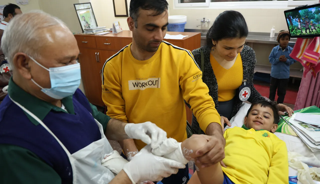 A medical professional and volunteers treat a child with clubfoot, through Ponseti method, at the CURE clinic in St Stephen’s Hospital, New Delhi.