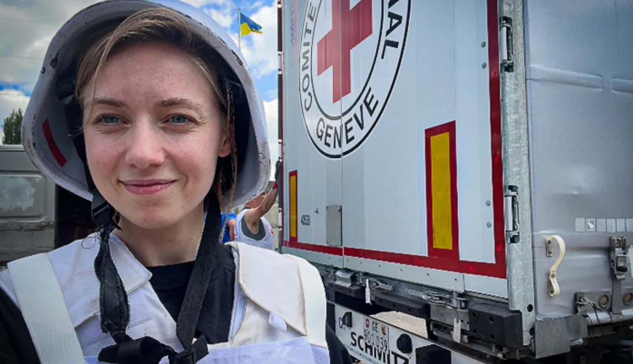 An ICRC worker standing in front of a marked truck