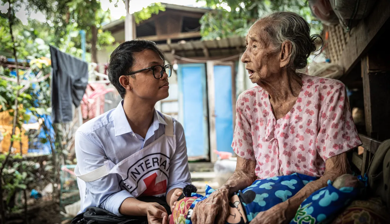 An ICRC worker with an elderly woman in Myanmar