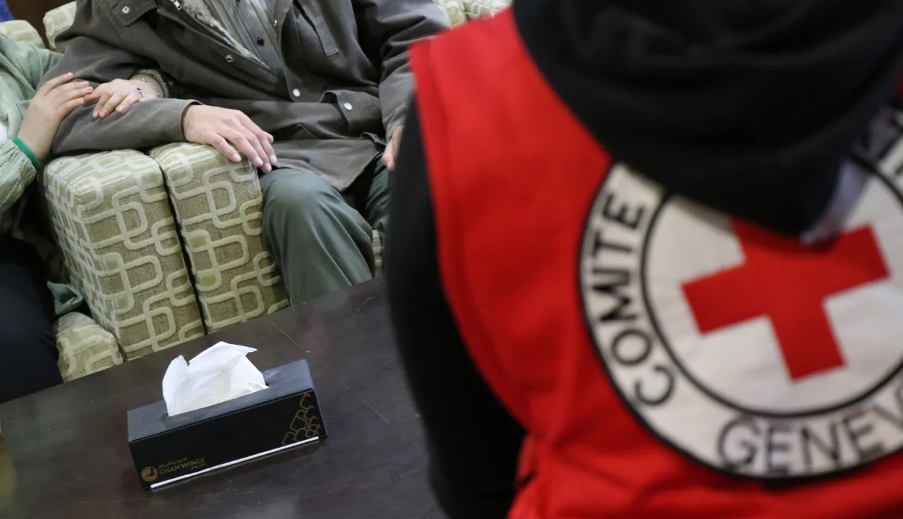 Two people sitting in front of ICRC staff
