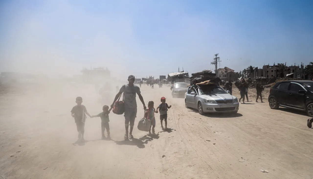 A father with his 4 children walking in an area full of sand