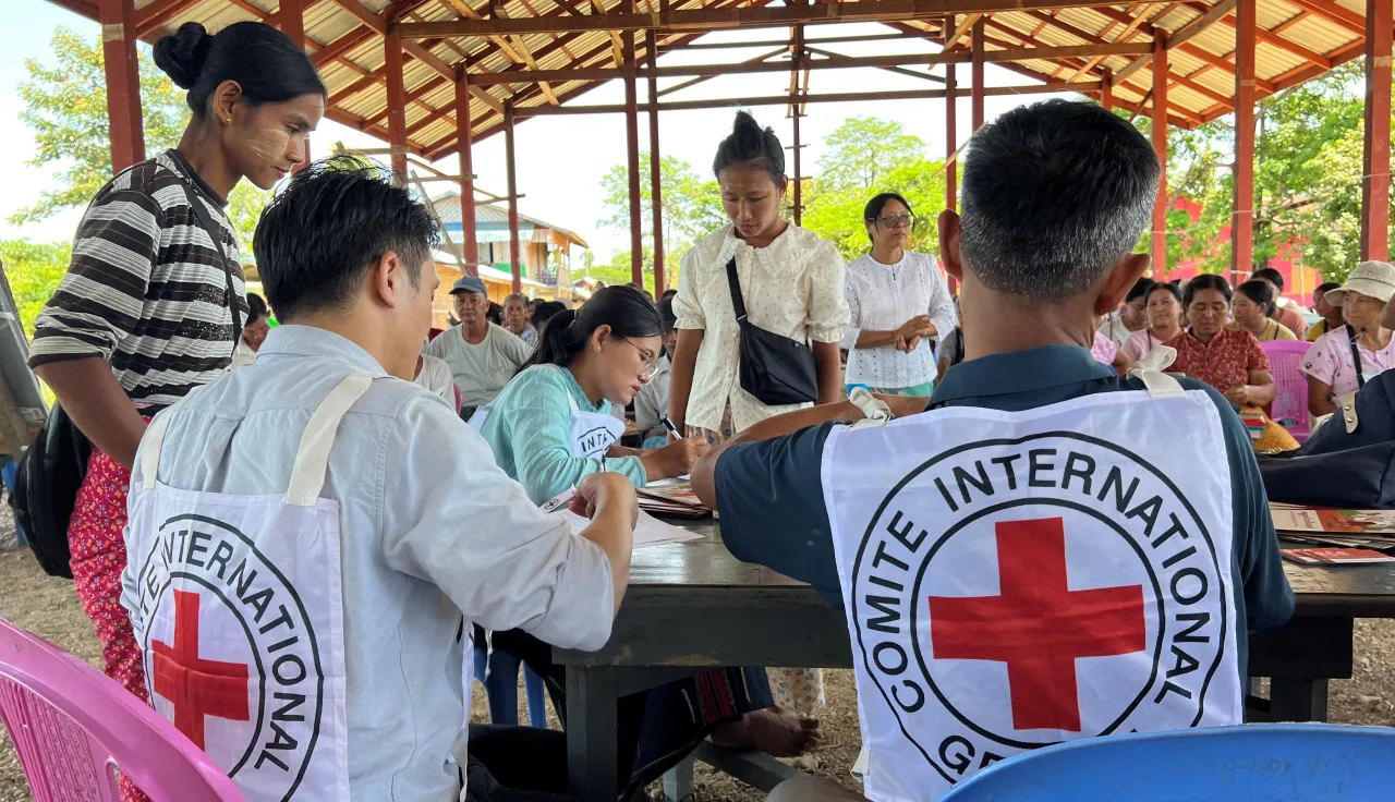 Two ICRC staff assisting people in Myanmar