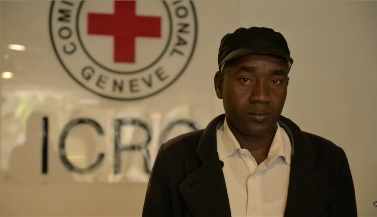Aly Mubarak, A Sudanese refugee, standing in front of ICRC emblem