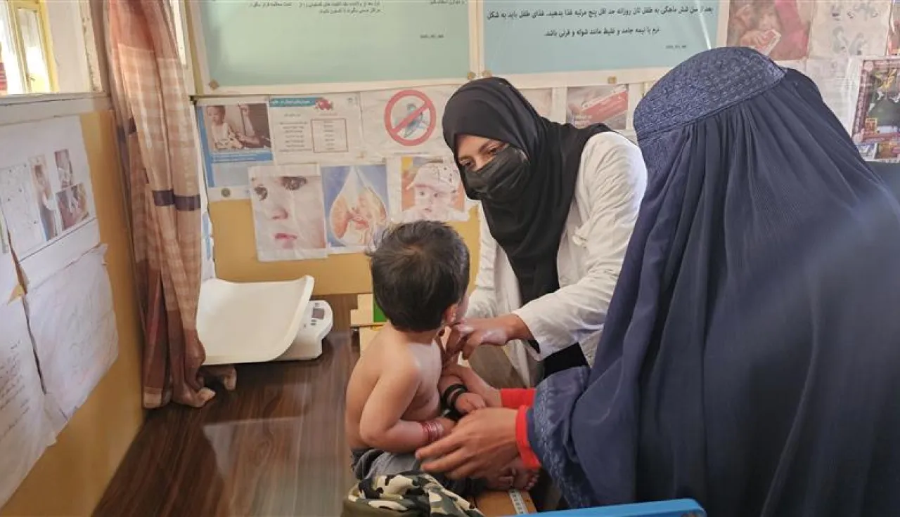 An Afghan Red Crescent Society (ARCS) healthcare worker examining a patient at an ARCS's clinic in Kabul