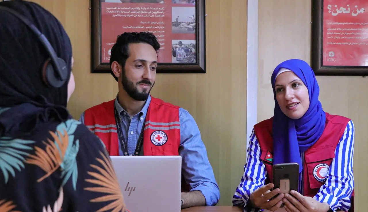 Mulher de uma comunidade conversa com voluntèarios do Crescente Vermelho Jordaniano.