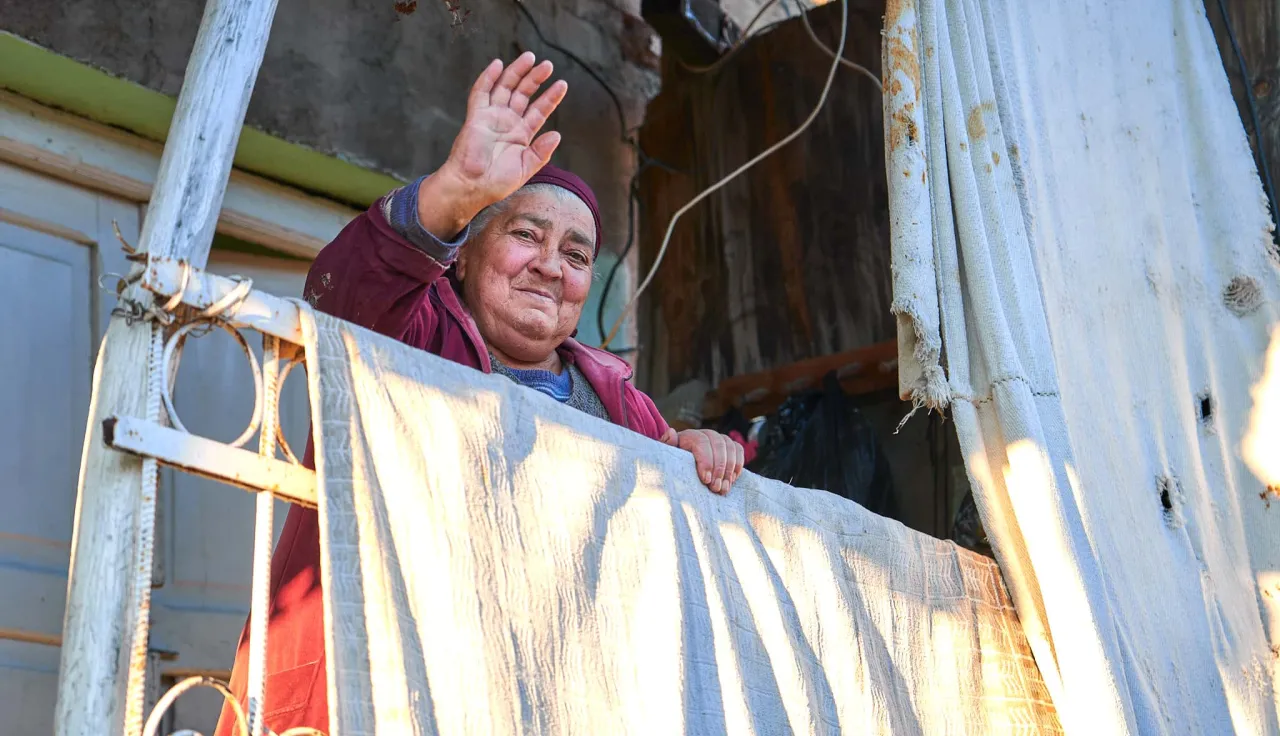 Manana (75) at the front door of her house greeting ICRC staff