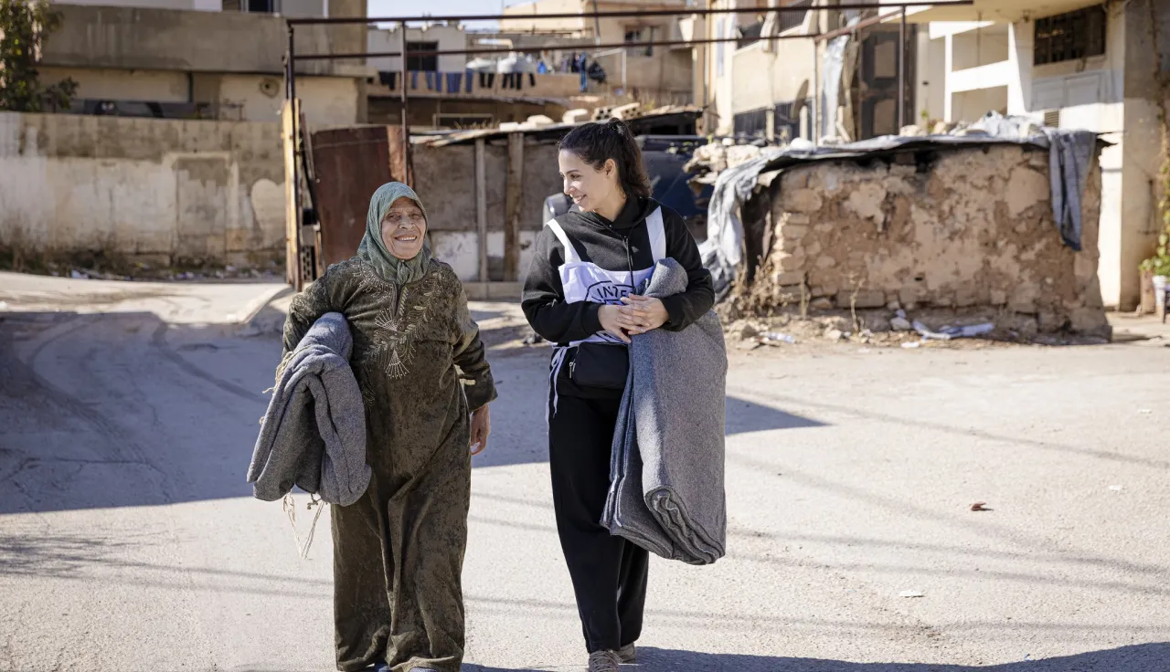 A staff member talks to a beneficiary during a distribution of aid items