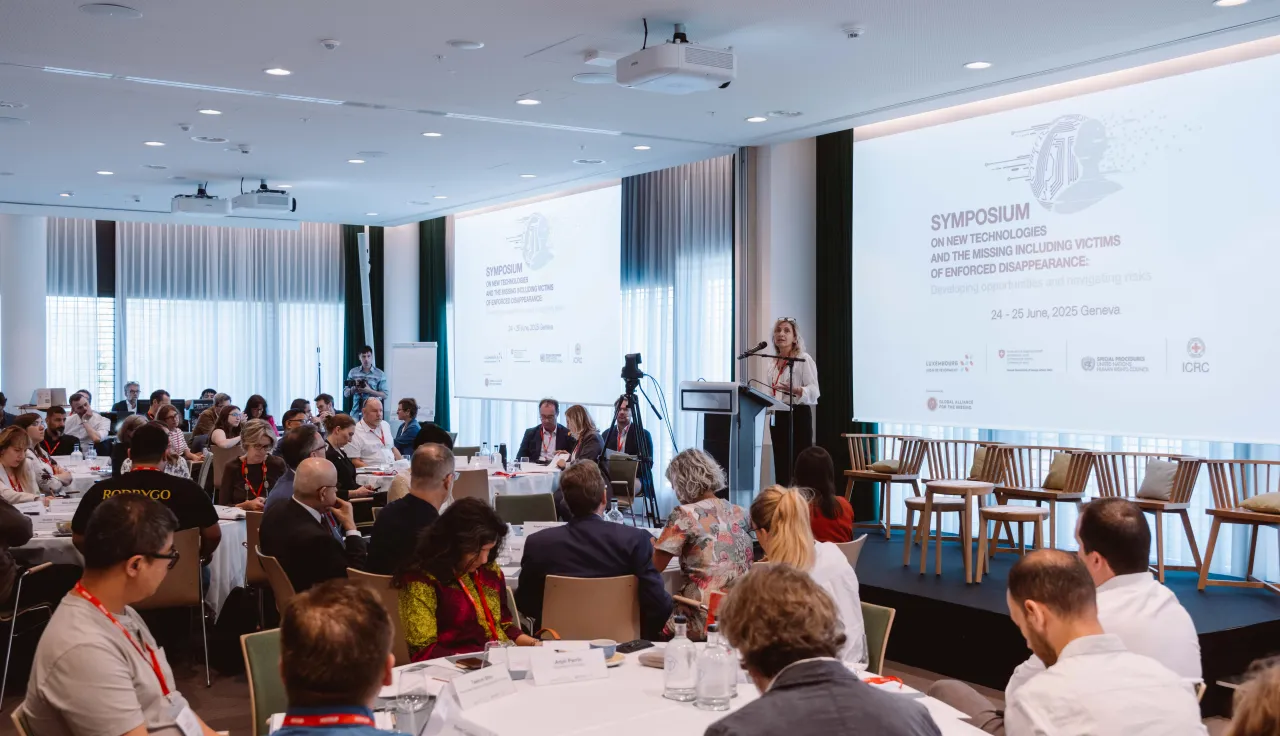 Group of search practioners and experts from various sectors in a conference room with a speaker on the stage