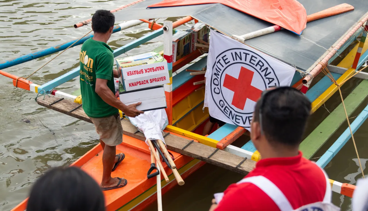 Las Navas, Northern Samar, Philippines. ICRC field officers and Philippine Red Cross volunteers loading into two boats EcoSec items for distribution 