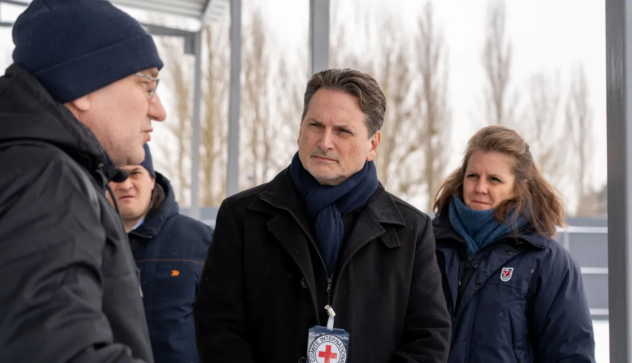 ICRC Director-General Pierre Krähenbühl speaks with a local resident outdoors in a winter setting, accompanied by a colleague.
