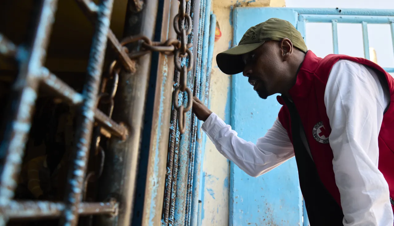 Un empleado del CICR habla desde afuera de la celda de una prisión