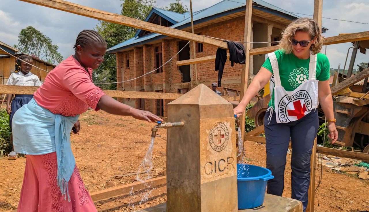 Two women collecting water from a water point.