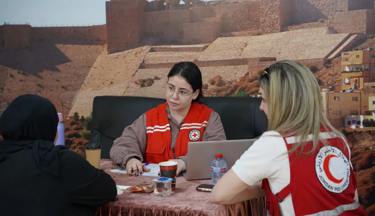 ICRC and Jordan Red Crescent Society PFL officers speaking with one of the families of missing persons, explaining the services and support that the ICRC can provide to these families.