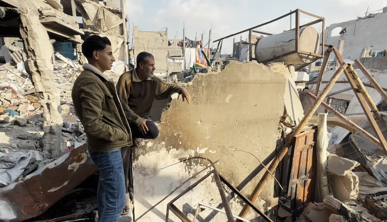 Iyad Wahidi, 53, sits on the ruins of his destroyed home in Jabalia, near the yellow line, where some families live in difficult conditions, with limited access to essential services, including water, sanitation, healthcare, and education.