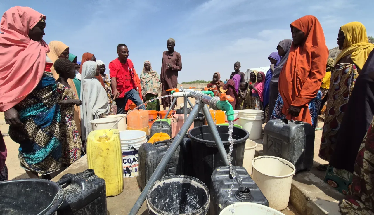 Community water point with community members fetching water