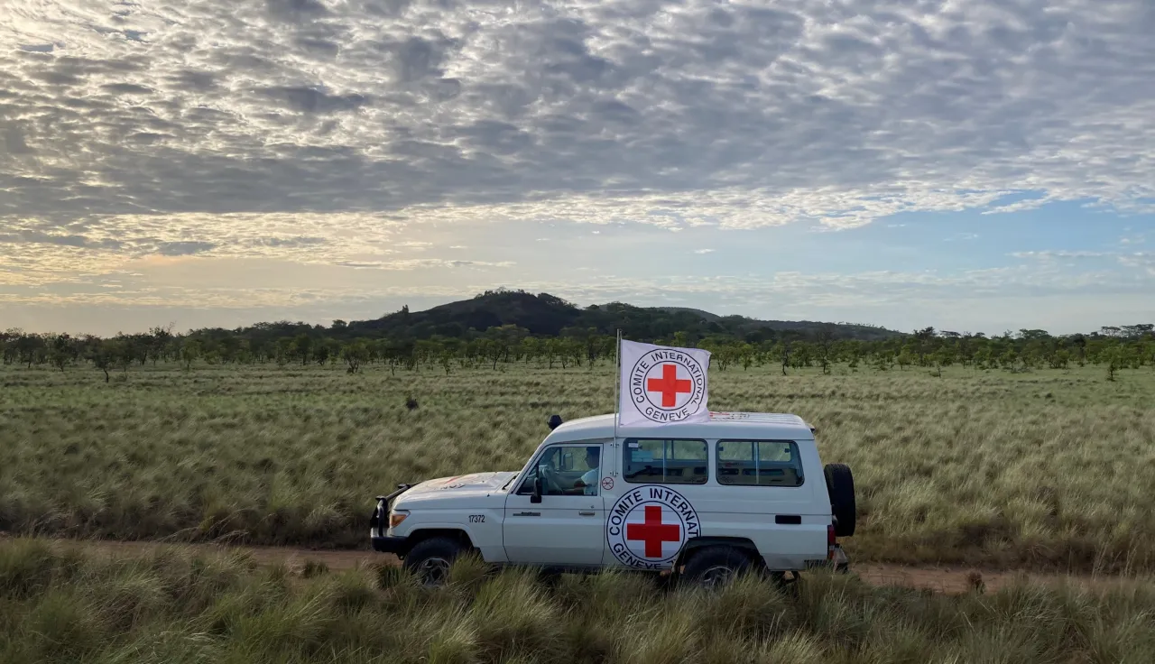 Un vehículo del CICR avanza por una carretera rodeada de montañas
