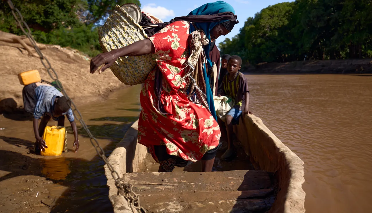 A woman navigates her seat in a boat in Somalia.