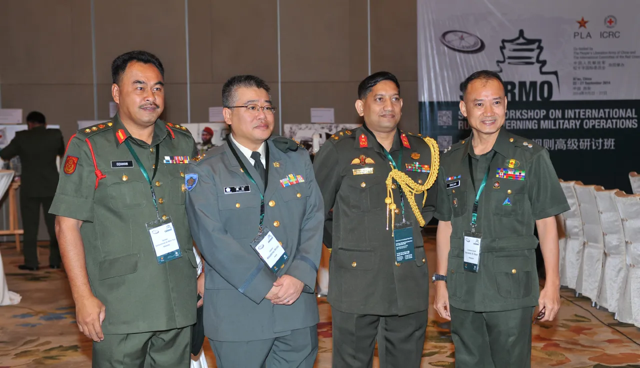 近60个国家的代表出席了2014年规制军事行动国际规则高级研讨班。照片中从左到右分别是：马来西亚的卡马鲁扎曼•本•穆赫德•萨尼（Kamarudzaman bin Mohd Thani）上校、日本的广田耕士朗（Koushirou Hirota）上校、孟加拉国的艾哈迈德•沙迈姆（Ahmed Shameem）准将以及菲律宾的西斯卡•埃尔南多（Siscar Hernando Jr.）中校。