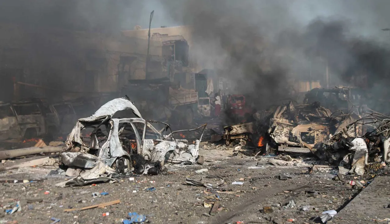 A street in ruins, littered with destroyed vehicles.